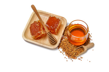 Sweet honeycomb and wooden honey dipper isolated on a white background.
