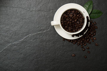 Obraz na płótnie Canvas Coffee beans in the cup on the black stone.