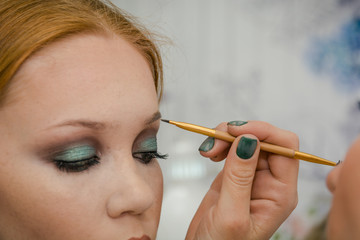 Obraz premium The girl makes up eyes in salon. Face care in salon.
