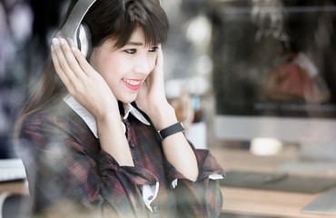 Young asian  woman listening to music with  headphones