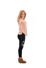 full length portrait of a girl wearing pink shirt and black floral pants. standing pose, isolated on white background.