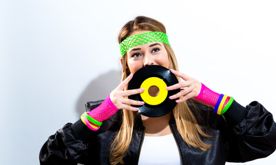Woman with a vinyl record in 1980's fashion on a white background