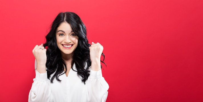 Successful Young Woman On A Solid Red Background