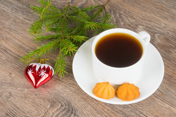 coffee cup with cookies and fir tree branch on rustic wooden background