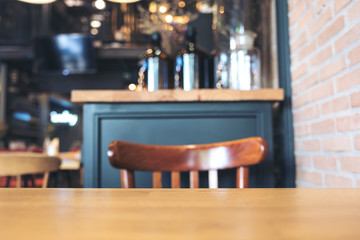 Wooden table and chairs in modern loft cafe with blur bokeh vintage background