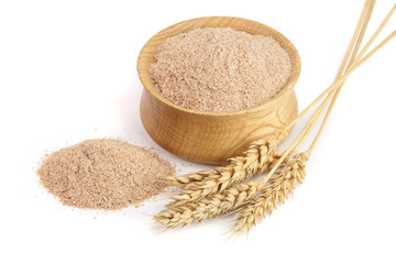 Pile of wheat bran in wooden bowl with ears isolated on white background