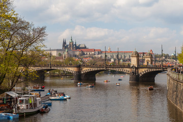 Fototapeta na wymiar PRAGUE, CZECH REPUBLIC - APRIL 12, 2017: View on the river Vltava, bridge and boats. Old town, summer season.