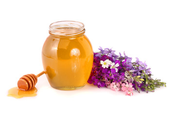Jar of honey with wildflowers isolated on white background
