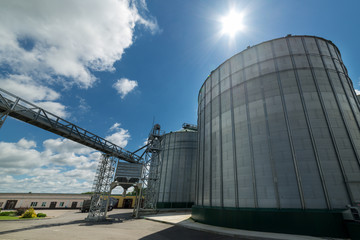 High metal silos for storage of wheat and barley. Sunny day, the blue sky. © nordroden