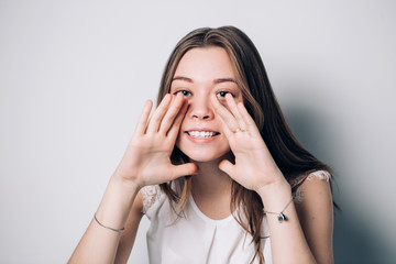 Attractive young sexy woman is announcing, telling a secret, shouting or yelling