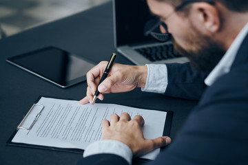 Business man with a beard working with documents in the office, writing, working