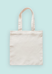 Tote bag canvas fabric cloth eco shopping sack mockup blank template isolated on pastel mint blue...
