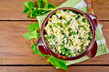 Couscous with spinach in bowl on board top