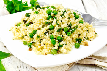 Couscous with spinach in plate on napkin