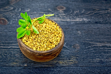 Fenugreek with leaf in clay bowl on black board