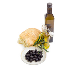 Black olives, olive oil, olive branch and ciabatta