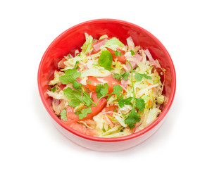 Top view of vegetable salad with ham in red bowl