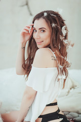 Fototapeta premium Portrait of beautiful young girl smiling in flying white feathers. clean soft body Beauty Woman Touching. Perfect Fresh Skin. Studio shot. Isolated on white wall background