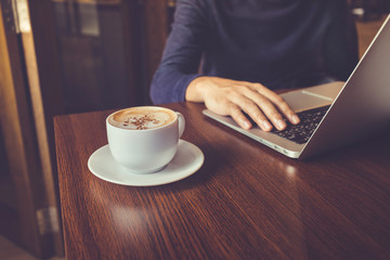Businessman working with laptop and coffee cup on desk table in cafe shop.Business inspiration