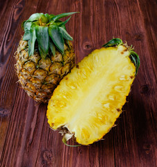 Pineapple with an a Half slice on the wood table.
