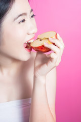 Asian woman with apple concept. She smiling and holding apple. Beauty face and natural makeup. Isolated over pink background.