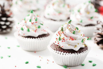 Chocolate cupcake decorated white cream and fir trees. Christmas sweets. New year dessert
