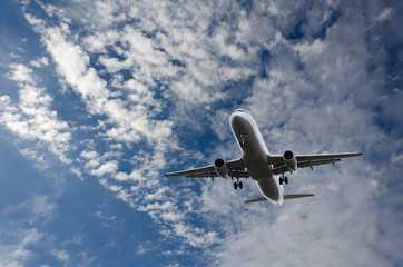 Fototapeta na wymiar Airplane flying in sky with clouds
