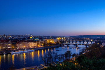 Fototapeta premium Panorama of the old part of Prague from the Letna park at dusk. Beautiful view on the bridges over the river Vltava at sunset. Old Town architecture, Czech Republic.