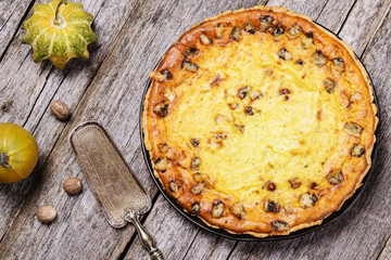 Homemade pumpkin pie, quiche, tart with blue cheese on vintage wooden table. French cuisine. Selective focus 