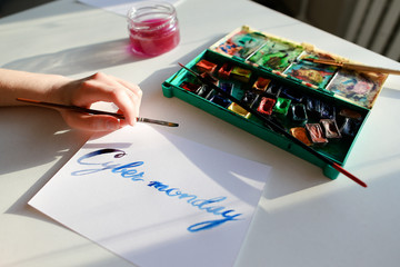 Female calligrapher creates inscription for sale, using brushes 