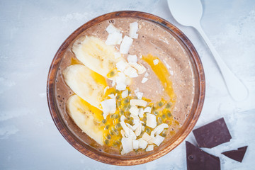 Smoothie bowl with chocolate, banana, coconut and passion fruit.