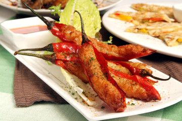 Meat stuffed red chili peppers on the white plate