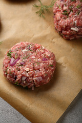 raw minced beef steak burgers on gray background