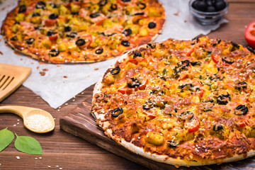 Delicious fresh pizza with chicken, tomatoes, cheese and black olives