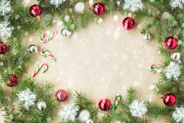 Fototapeta na wymiar Festive christmas border with red balls on fir branches and snowflakes with snow on rustic beige background