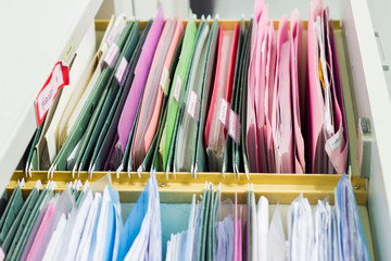 blurred files document of hanging file folders in a drawer in a whole pile of full papers, the concept 