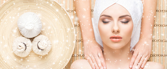 Young and healthy woman getting health care treatments in massaging salon. Winter and Christmas spa...