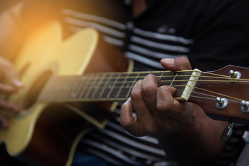 Fototapeta premium Man playing guitar worship christian jesus. Close-up of men playing acoustic guitar. warm tone. American Artist playing to music.