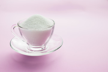Bowl and scoop with white sand and lump sugar on wooden background