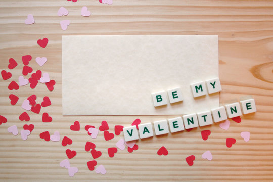 St Valentine's day: a love note for the loved one, with pink and red hearts and letters on a wooden table