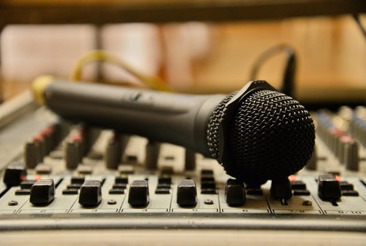 Microphone laying on the sound mixer. Professional audio equipment.