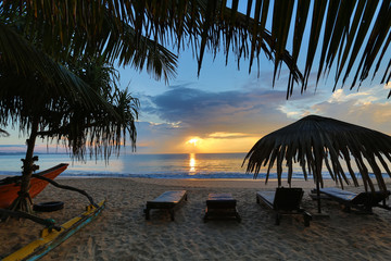 Sun loungers with umbrella on the beach, sunrise