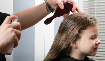 young girl doing a hairdress, wetting her hair, she smiles © kurgu128