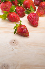 red strawberries on a light wooden board, like a background