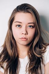 Fototapeta premium Portrait of beautiful blue-eyed girl, close-up, sad, serious gaze to the camera