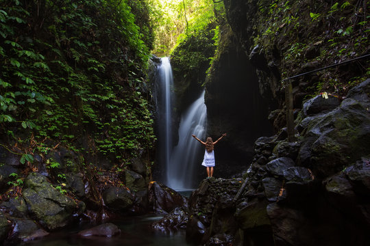 Woman posing near Gitgit waterfall on Bali in indonesia