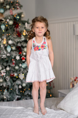 Merry Christmas celebration. Beautiful little girl in a amazing dress near the Christmas tree. Christmas miracles. Happy New Year