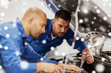 mechanic men with wrench repairing car at workshop