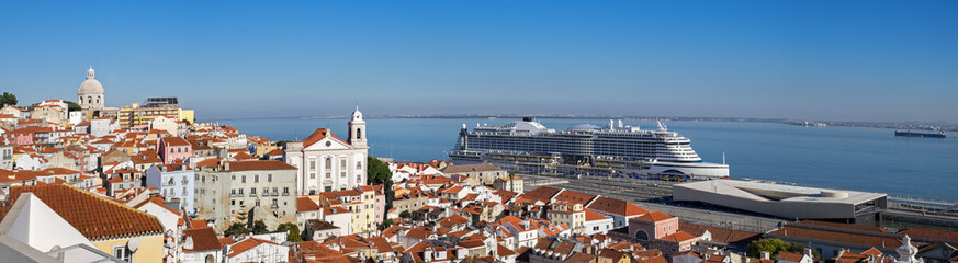 Fototapeta na wymiar Very large panoramic view on Sao Vicente de Fora church, red roofs on Lisbon centre and big cruise liner ship on Tagus River. Portugal
