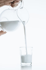 person pouring milk into glass